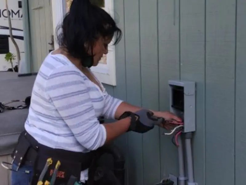 Licensed electrician wiring an exterior subpanel in Rush
